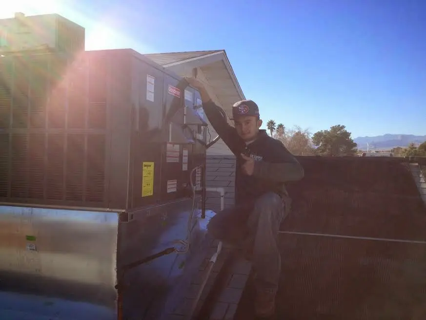 HVAC technician performing Air Duct Cleaning on a rooftop unit in West Sacramento